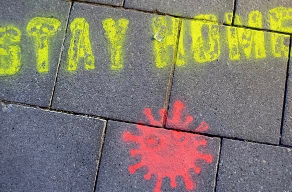 The words "Stay Home" and a viral image were spray-painted on a street.